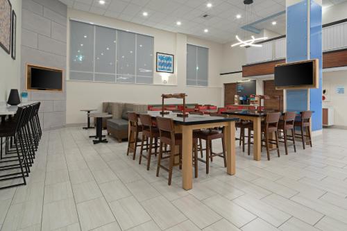 a dining area with tables and chairs in a room at Holiday Inn Express Seattle - Sea-Tac Airport by IHG in SeaTac