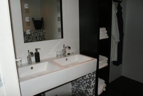 a bathroom with a white sink and a mirror at B&B Van Hunebed Naar Jullie Bed in Schoonoord