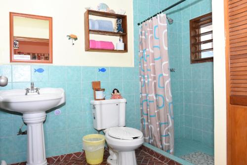 y baño con aseo y lavamanos. en CANCUN GUEST HOUSE, en Cancún