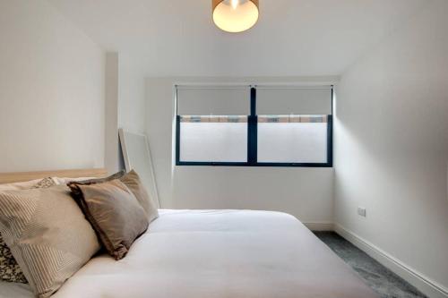 a white bed in a room with a window at Stylish Sheffield City Spot in Sheffield