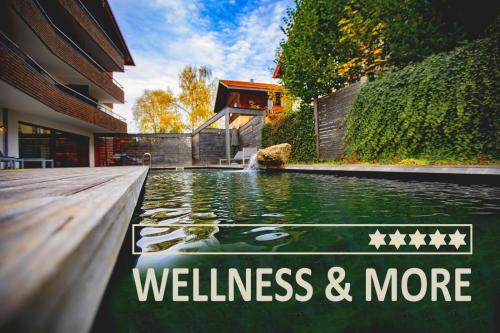 a swimming pool in a house with the words wellness and more at Chalet Sinswang am Hochgrat in Oberstaufen