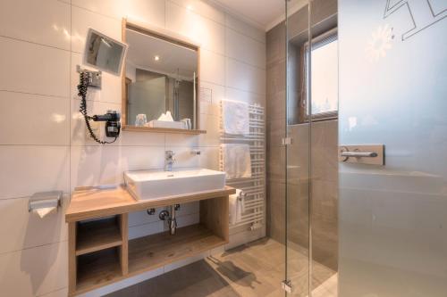 a bathroom with a sink and a shower at Aparthotel Acksteiner in Sankt Anton am Arlberg