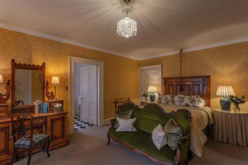 a bedroom with a bed and a chair and a table at Glenapp Castle in Ballantrae