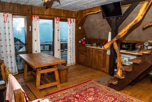 una camera con tavolo e una cucina con finestre di Oak House a Palyanytsya