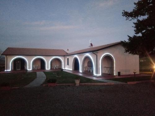 a large white building with arches and lights on it at Agriturismo il Giardino in Saturnia