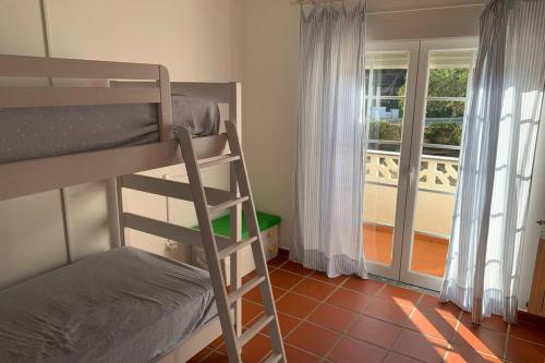 a bedroom with a bunk bed and a balcony at Golf, Beach & Pool House in Amoreira