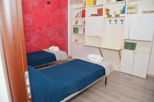 Habitación pequeña con 2 camas y estante para libros en La Casa Di MIK, en Ovada