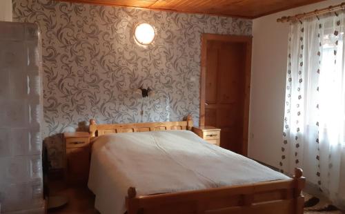 ein Schlafzimmer mit einem Bett und einer Wand in der Unterkunft Pensiunea Laura in Bran