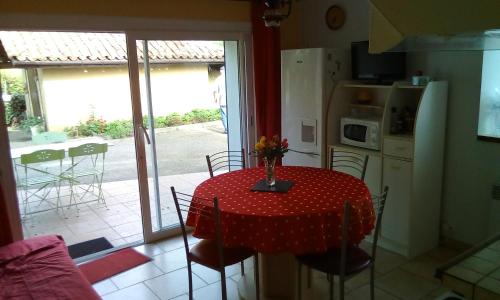 une cuisine avec une table et un chiffon rouge de polka dans l'établissement Appartement a la campagne, à Poyanne