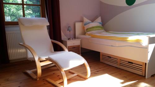 a childs bedroom with a bed and two chairs at Landhaus Aballo - Ferienwohnung in grüner Oase mit Ruhe und Komfort in Utarp