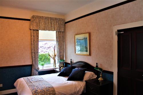 1 dormitorio con cama y ventana en Loch Arklet House, en Stirling