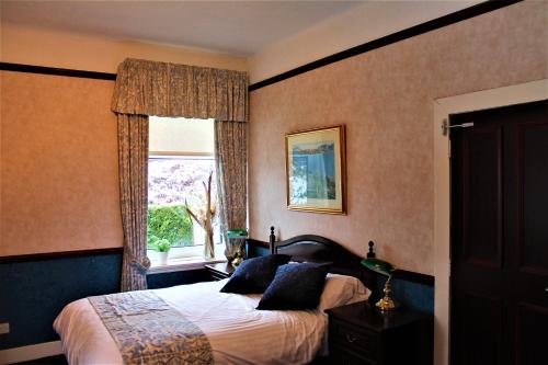 a bedroom with a bed and a window at Loch Arklet House in Stirling