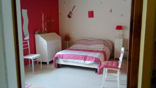 een slaapkamer met een bed, een dressoir en een stoel bij Appartement a la campagne in Poyanne