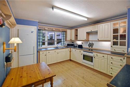 a kitchen with white cabinets and a wooden table at Unique, perfectly located town centre house in Lerwick