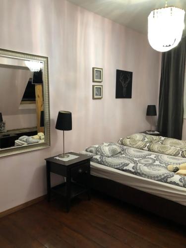 a bedroom with a bed and a mirror and a table at Pałac Myśliwski Orle in Mirosławiec