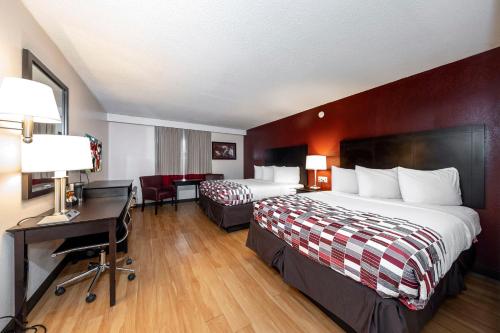 a hotel room with two beds and a desk at Red Roof Inn Lumberton in Lumberton