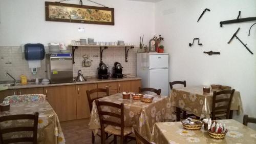 a kitchen with two tables and a kitchen with a refrigerator at Agriturismo La Cantina San Martino in Assisi