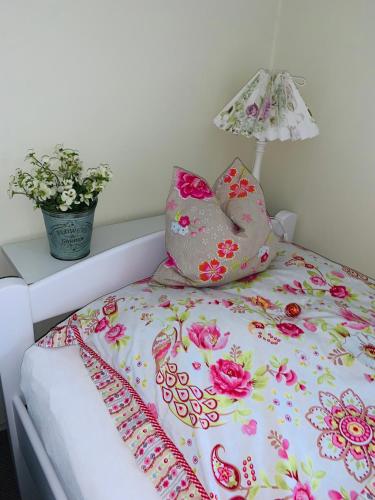 a bed with pillows on it with a lamp on it at Haus Boy Jensen Wohnung Sonnenplatz in Wenningstedt