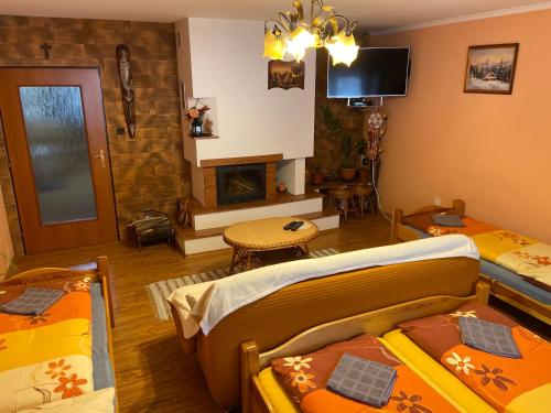 a living room with two beds and a fireplace at Privát u Zdenky in Lazy pod Makytou
