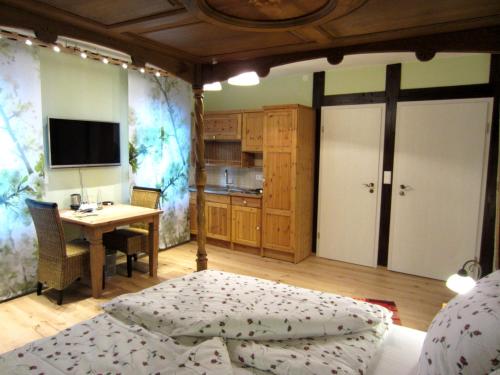 a bedroom with a bed and a table and a desk at Cleo´s Hotel Kallstadt in Kallstadt