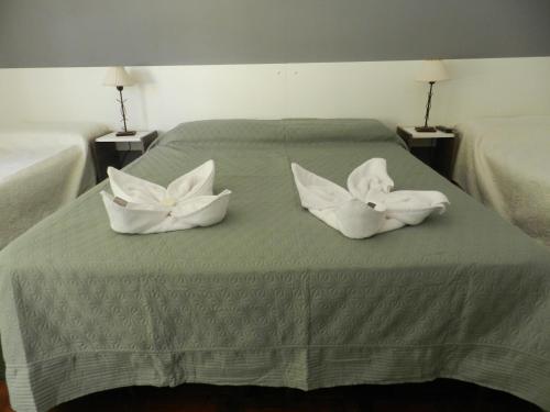 a green bed with two white pillows on it at Hotel 376 in Villa Carlos Paz