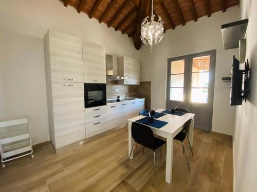 a kitchen with white cabinets and a table and chairs at Il Cerro in Arezzo
