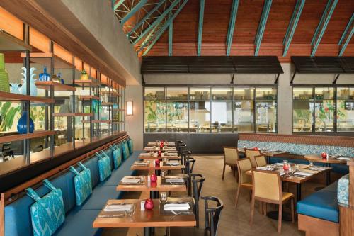 a row of tables in a restaurant with blue seats at Secrets La Romana All-Inclusive Adult Only Resort & Spa in Bayahibe