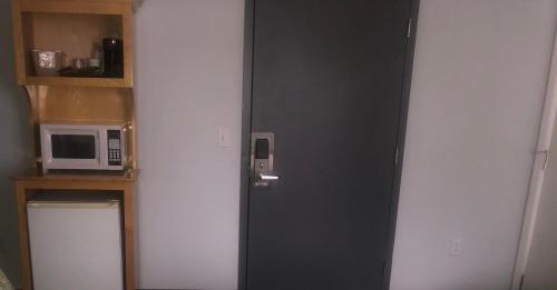 a black door in a room with a microwave at The Atlantic House in Narragansett