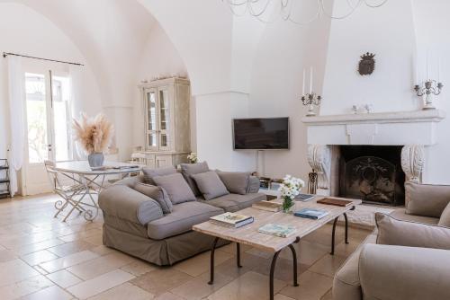 a living room with a couch and a fireplace at Masseria Don Luigi-Luxury Farmhouse in Savelletri di Fasano