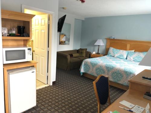 a hotel room with a bed and a microwave at The Atlantic House in Narragansett
