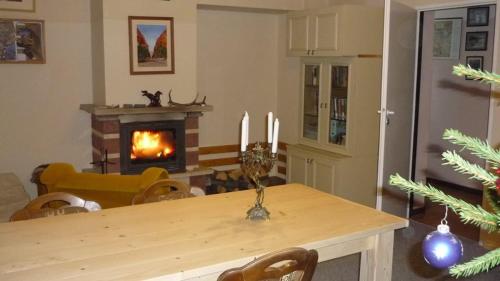 a living room with a table with a fireplace at Birkut Szkoła Przetrwania 1 in Lasowka