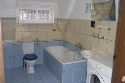 a bathroom with a tub and a toilet and a sink at Birkut Szkoła Przetrwania 1 in Lasowka
