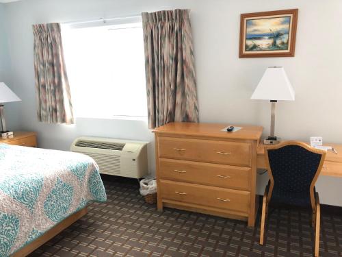 a hotel room with a bed and a desk and a window at The Atlantic House in Narragansett