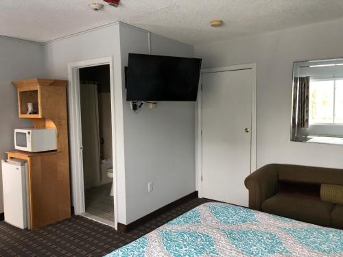 a bedroom with a bed and a television on the wall at The Atlantic House in Narragansett