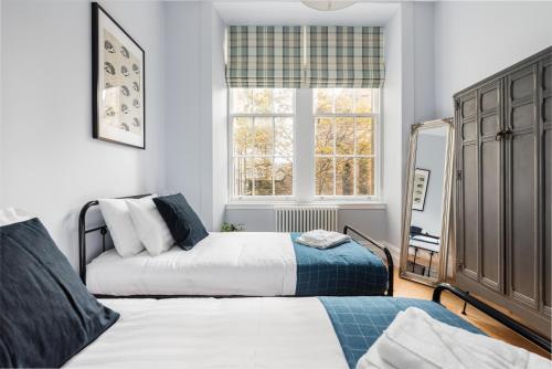 1 dormitorio con 2 camas y ventana en Luxury Royal Mile Retreat en Edimburgo