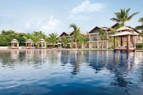 a swimming pool in front of a resort at Hilton La Romana All- Inclusive Adult Resort & Spa Punta Cana in Bayahibe