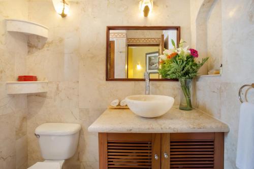 La salle de bains est pourvue d'un lavabo, de toilettes et d'un miroir. dans l'établissement Porto Playa Condo Hotel and Beach Club, à Playa del Carmen