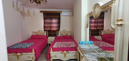 a bedroom with two beds and a mirror at Charming sunset,Panoramic Nile view & pyramid view in Cairo