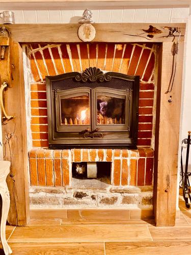 a brick fireplace in a living room with a fire place at Oca Carolina in Buttigliera Alta
