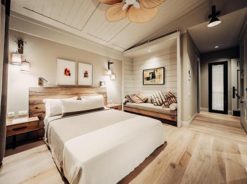 a bedroom with a large white bed and a couch at Bernadet Alaçatı in Alaçatı