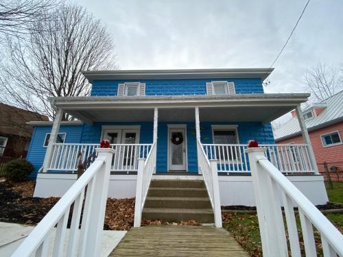 a blue house with stairs in front of it at Devil's Lake Inn and Devil's Lake Inn Too in Manitou Beach