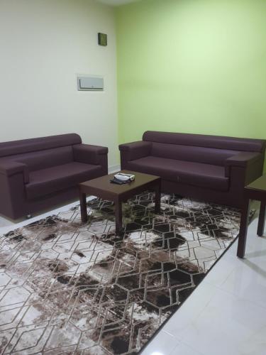 a living room with two couches and a coffee table at قصر الضيافة للشقق الفندقية in Muscat