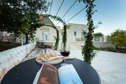 una mesa con un libro y una copa de vino en Trullo dei maestri en Locorotondo