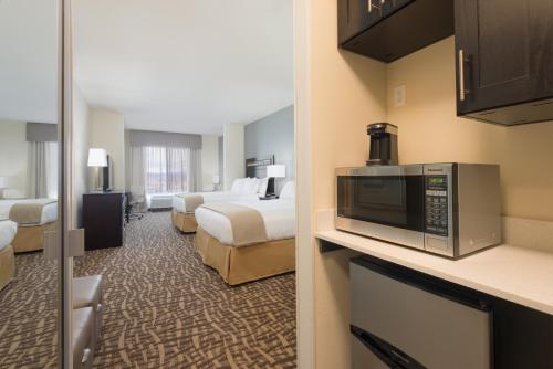 a hotel room with two beds and a microwave at Holiday Inn Express & Suites Denver South - Castle Rock by IHG in Castle Rock
