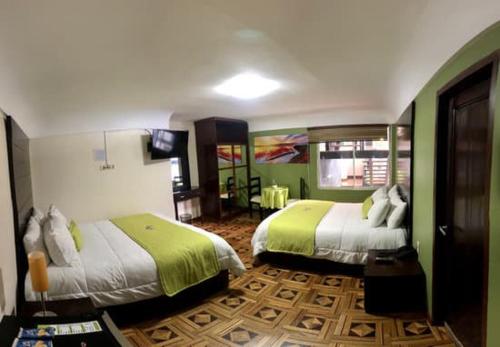 2 camas en una habitación con verde y blanco en Casa Hotel Achumani, en La Paz