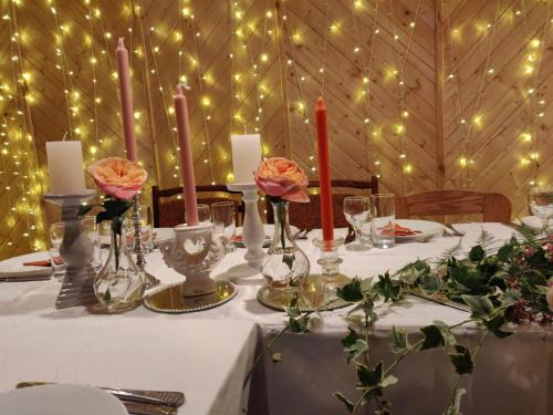 a table with candles and flowers in a room with lights at Veccepļi kempings in Spāre