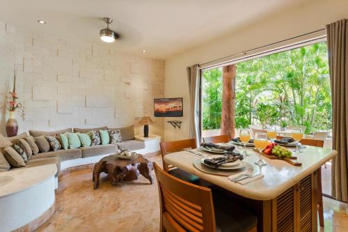 a living room with a table and a large window at Porto Playa Condo Hotel and Beach Club in Playa del Carmen
