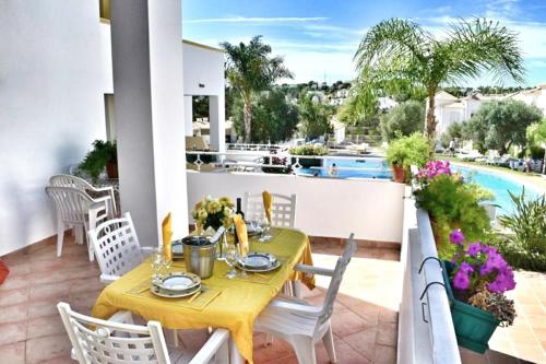 a dining table on a balcony with a view of a pool at Villa Algarve- Townhouse in Farm Village, Albufeira in Albufeira