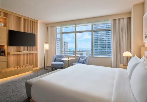 a hotel room with a bed and a large window at Hotel AKA Brickell in Miami