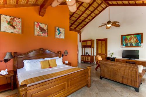 1 dormitorio con 1 cama con pared de color naranja en The Colonial at Jaguar Reef, en Hopkins